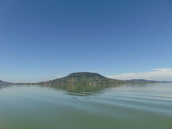 Scenic view of lake against clear blue sky