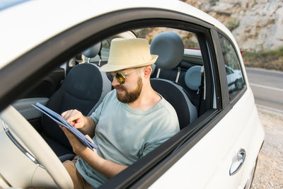 Side view of woman sitting in car