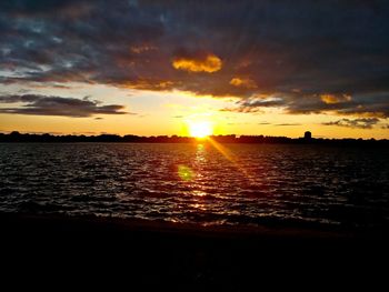 Scenic view of sea against dramatic sky during sunset
