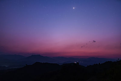 Scenic view of silhouette mountains against sky at night