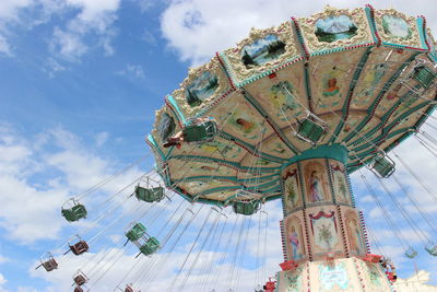 Low angle view of chain swing ride against sky