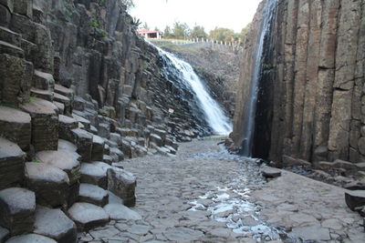 Scenic view of waterfall against sky