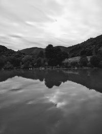 Scenic view of lake by mountains against sky