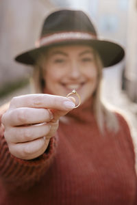 Portrait of smiling young woman holding ring 