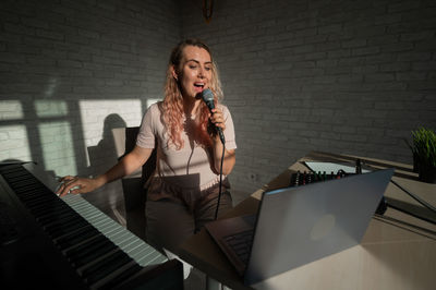 Woman singing while playing piano