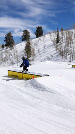 Man skiing on snowy field against sky