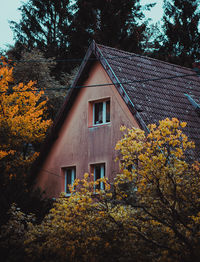 House and trees against sky during autumn