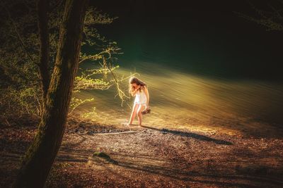 Side view of woman standing on land in forest