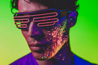 Close-up of man with multi colored face paint wearing eyewear