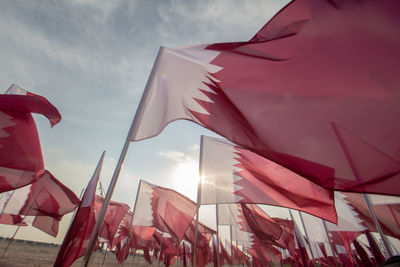 Low angle view of flags hanging against sky