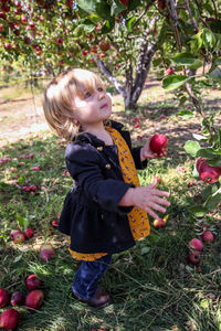 Full length of boy holding apple standing outdoors