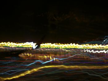 Close-up of illuminated water against sky at night