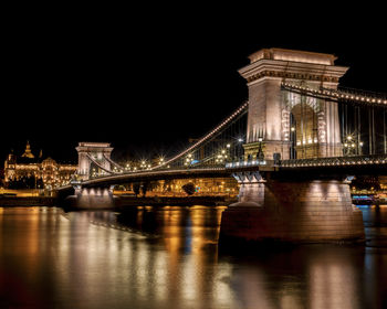Illuminated chain bridge over river at night in budapest