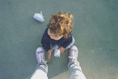 High angle view of girl sitting outdoors