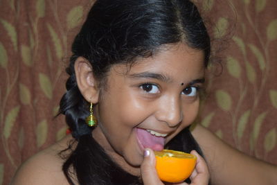 Close-up portrait of a smiling young woman drinking water