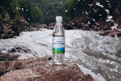 Close-up of water bottle on rock