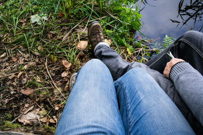 Low section of men sitting at lakeshore