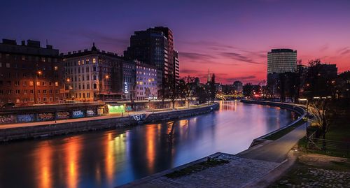 Illuminated bridge over river at night