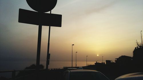 Street light on road against sky at sunset