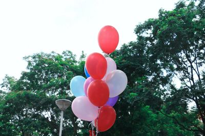 Low angle view of balloons against sky