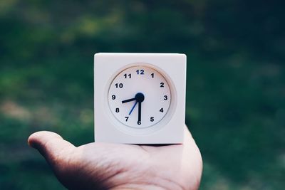 Cropped hand holding alarm clock