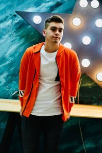 Portrait of young man standing in illuminated water