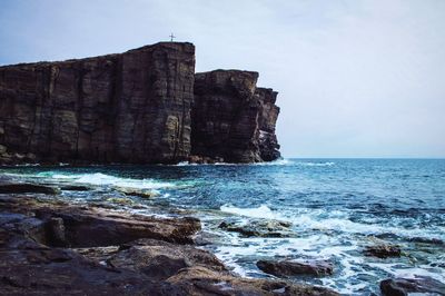 Scenic view of rocky cliffs and coastline next to sea