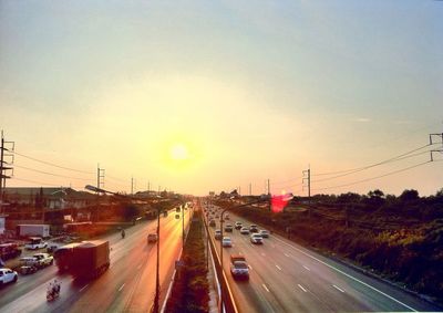 Traffic on road at sunset