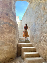 Rear view of woman standing on rock formations