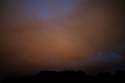 Low angle view of silhouette trees against sky at sunset