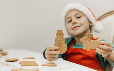The kid is holding a gingerbread cookies. cooking christmas cookies.
