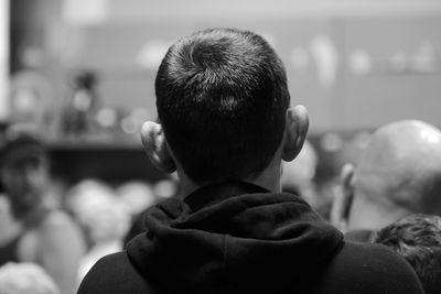 Rear view of man sitting at auction