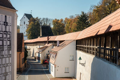 Street amidst houses and buildings against sky