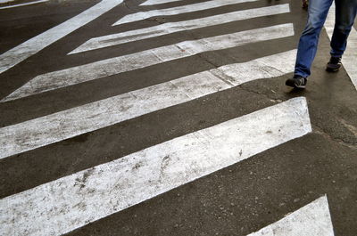 Low section of man walking on road