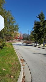 Road in city against clear blue sky