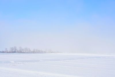 Scenic view of frozen landscape against clear blue sky