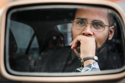 Close-up of man seen in side-mirror