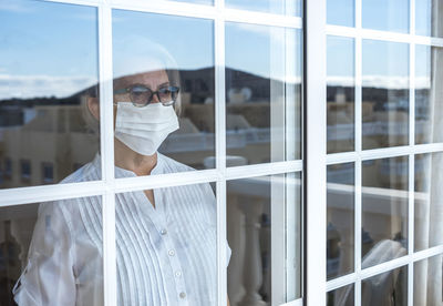 Portrait of young man standing by window