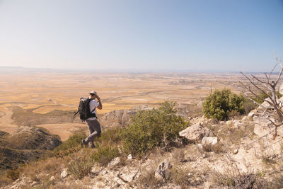 Man on rocks against clear sky