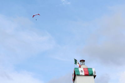 Low angle view of man flying against sky