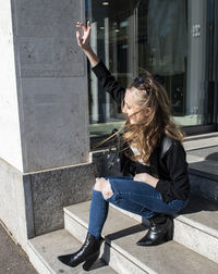 Full length of woman sitting outdoors