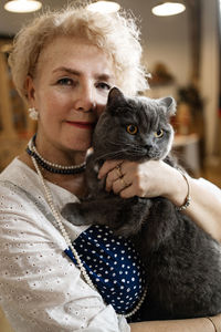 Portrait of senior woman with cat at home