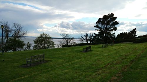 Scenic view of grassy field against cloudy sky