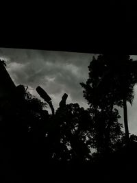 Low angle view of silhouette trees against sky