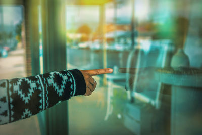 Midsection of man seen through glass window