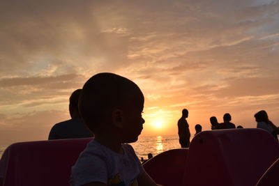 Portrait of people on shore against sky during sunset