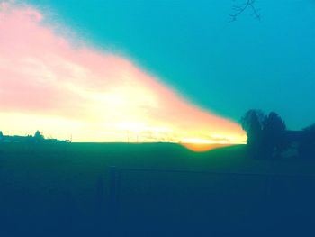 Scenic view of field against sky at sunset