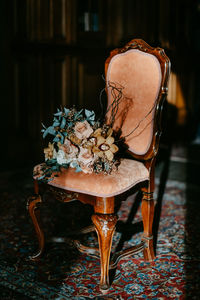 Close-up of potted plant on chair at home