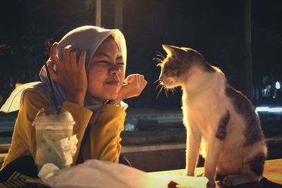Woman in hijab looking at cat 