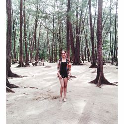 Portrait of young woman standing in forest